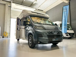 Autocaravana perfilada Rapido 696F con cabina gris y puerta lateral abierta